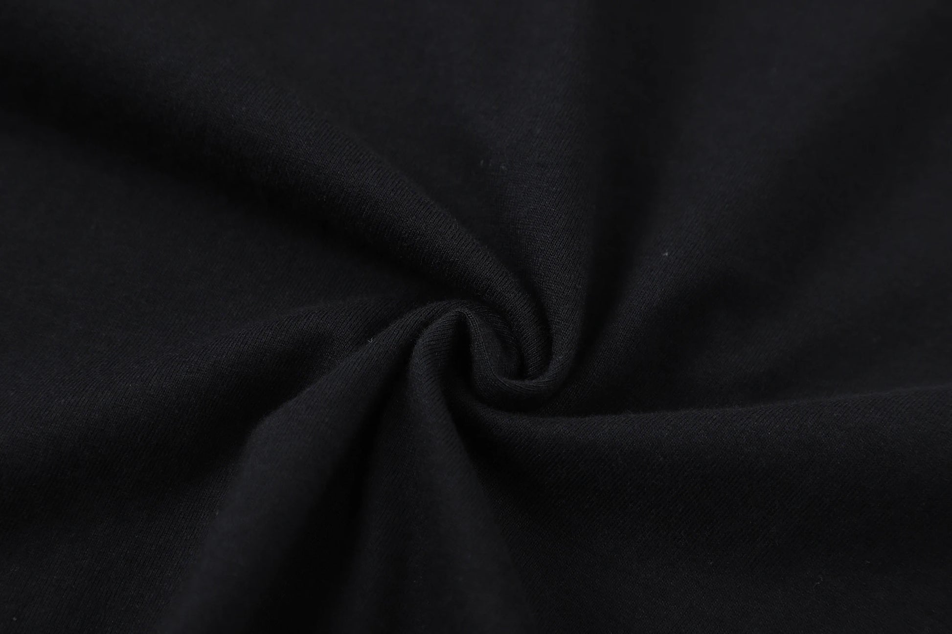 Close-up of black cotton fabric, showcasing soft and smooth texture suitable for T-shirt designs.