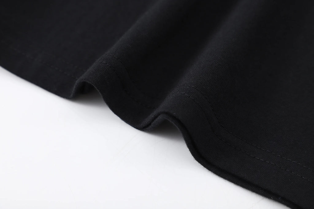 Close-up of the hem and fabric detail of a black t-shirt featuring a soft, comfortable texture.