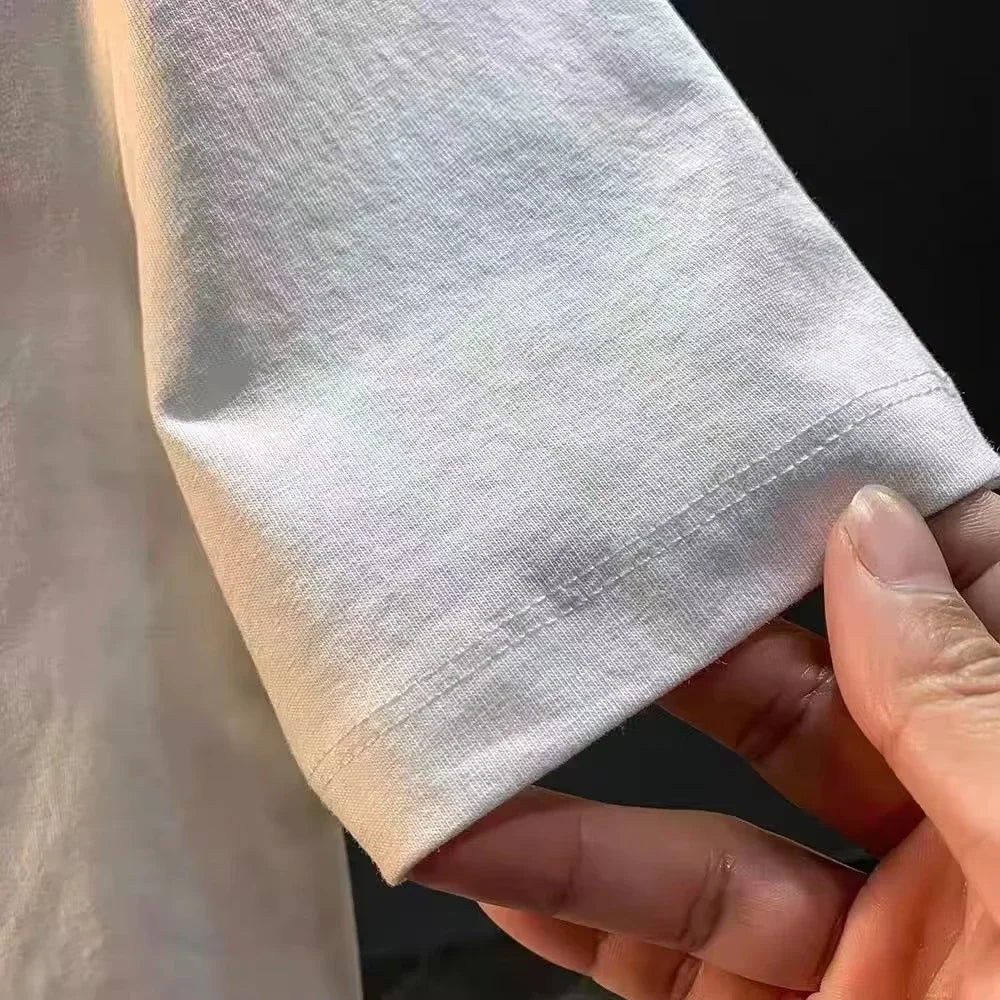 Close-up of the sleeve of a white anime-themed t-shirt showcasing high-quality fabric and stitching.