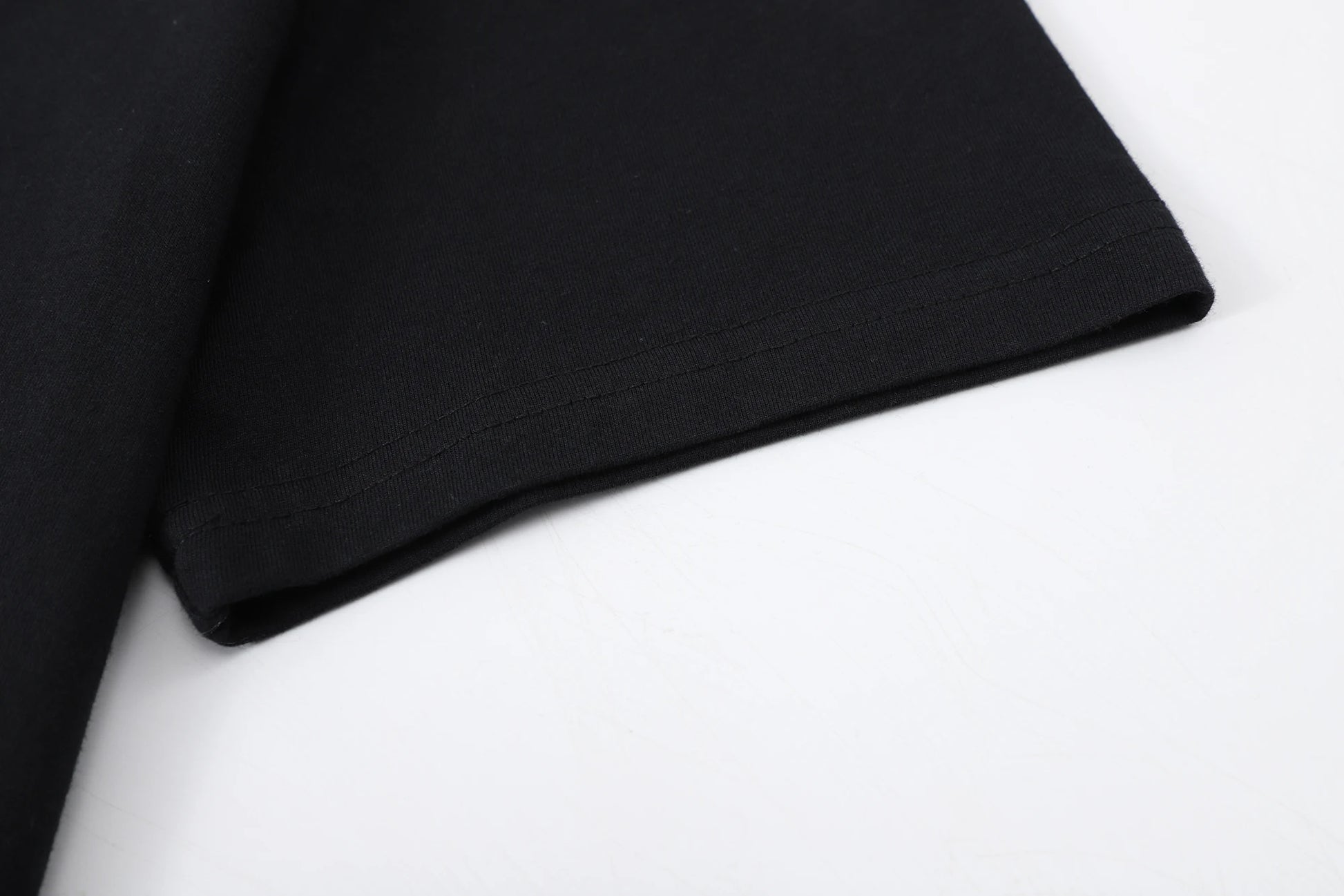 Close-up of the sleeve hem of a black Alucard graphic cotton t-shirt, showcasing its knit fabric and pull-on design.