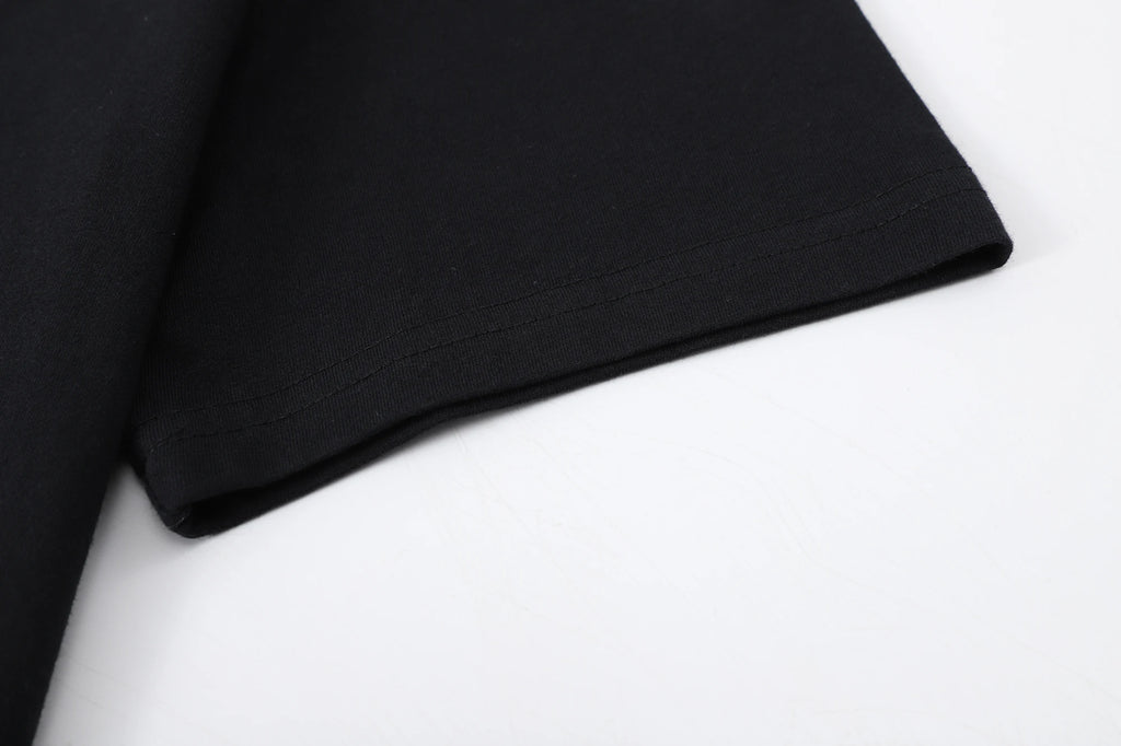 Close-up of the sleeve hem of a black cotton t-shirt, showcasing soft fabric and neat stitching.